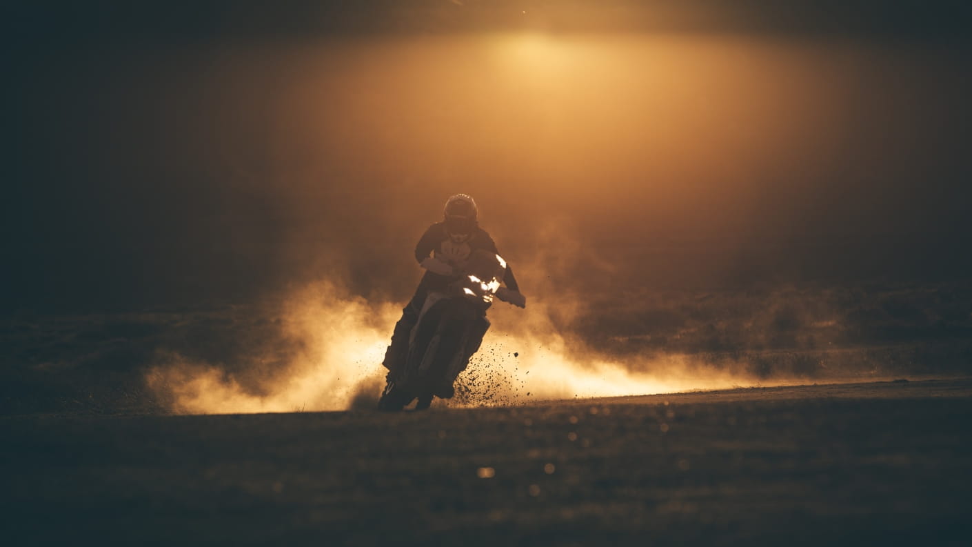 Low light image of rider on a Triumph motorcycle with mist